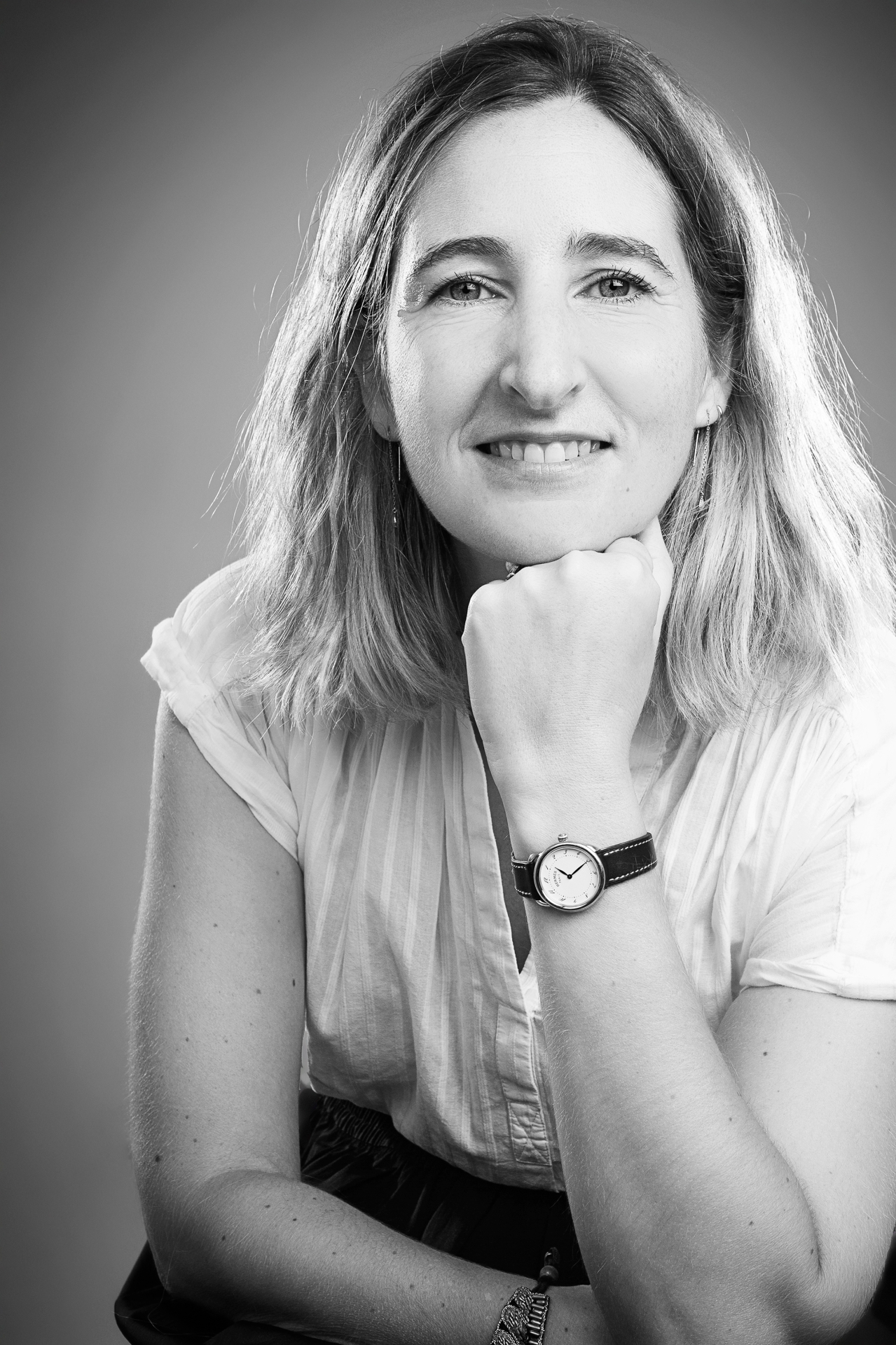 Black-and-white portrait of Juliette Neouze, hand under her chin, direct gaze
